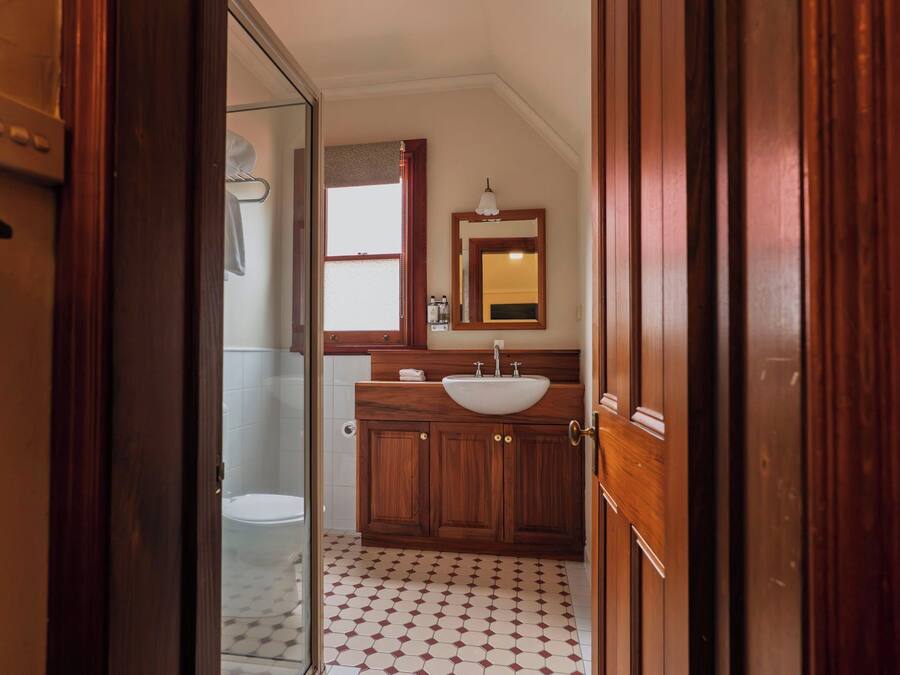 A bathroom with a wooden vanity, a sink, and a mirror.