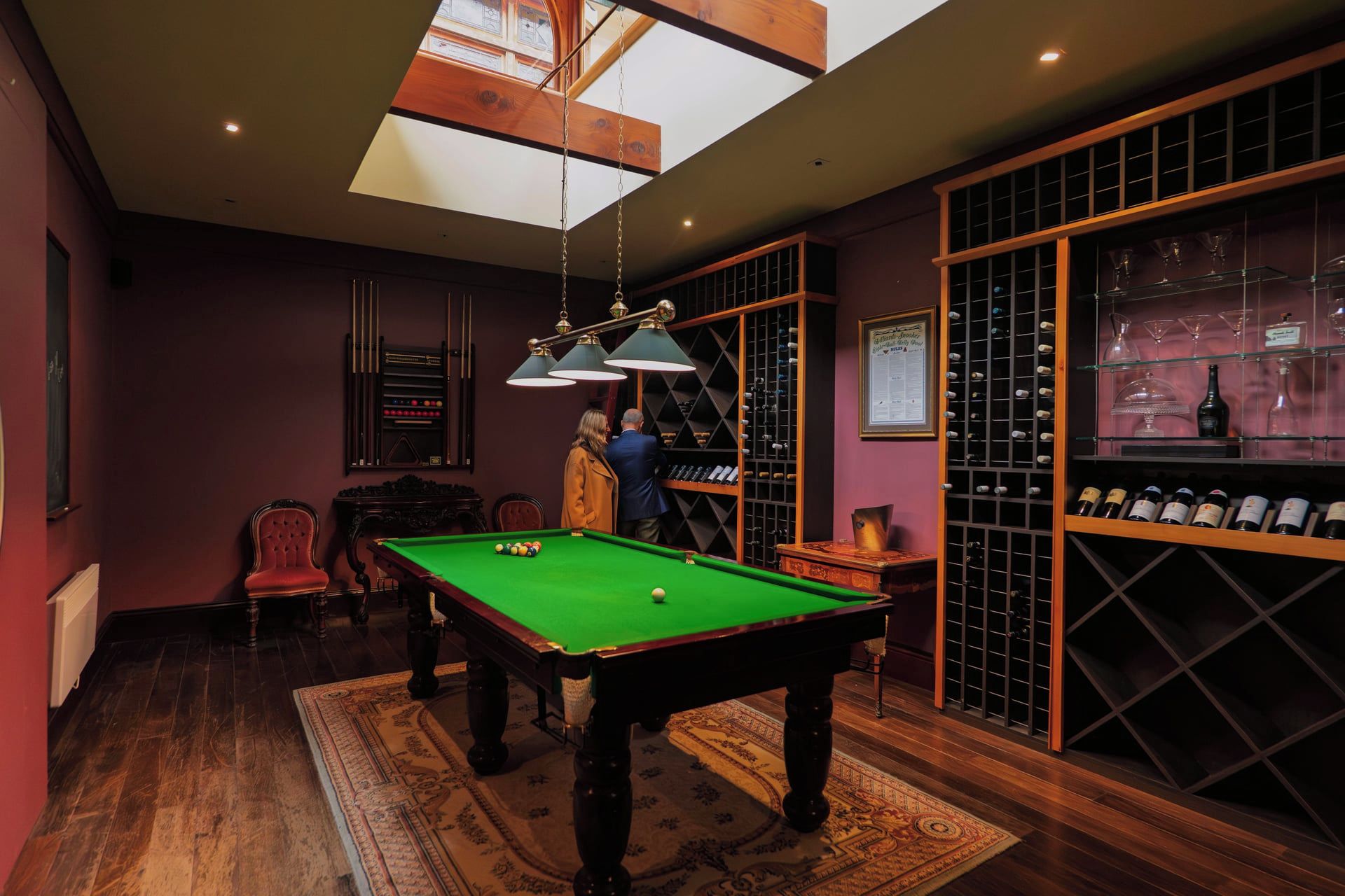 Uma sala de jogos com mesa de bilhar, adega e bar.