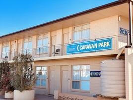 A two-story motel with a sign for 'Caravan Park' and 'Opal Inn' indicating motel rooms on the left and units on the right.