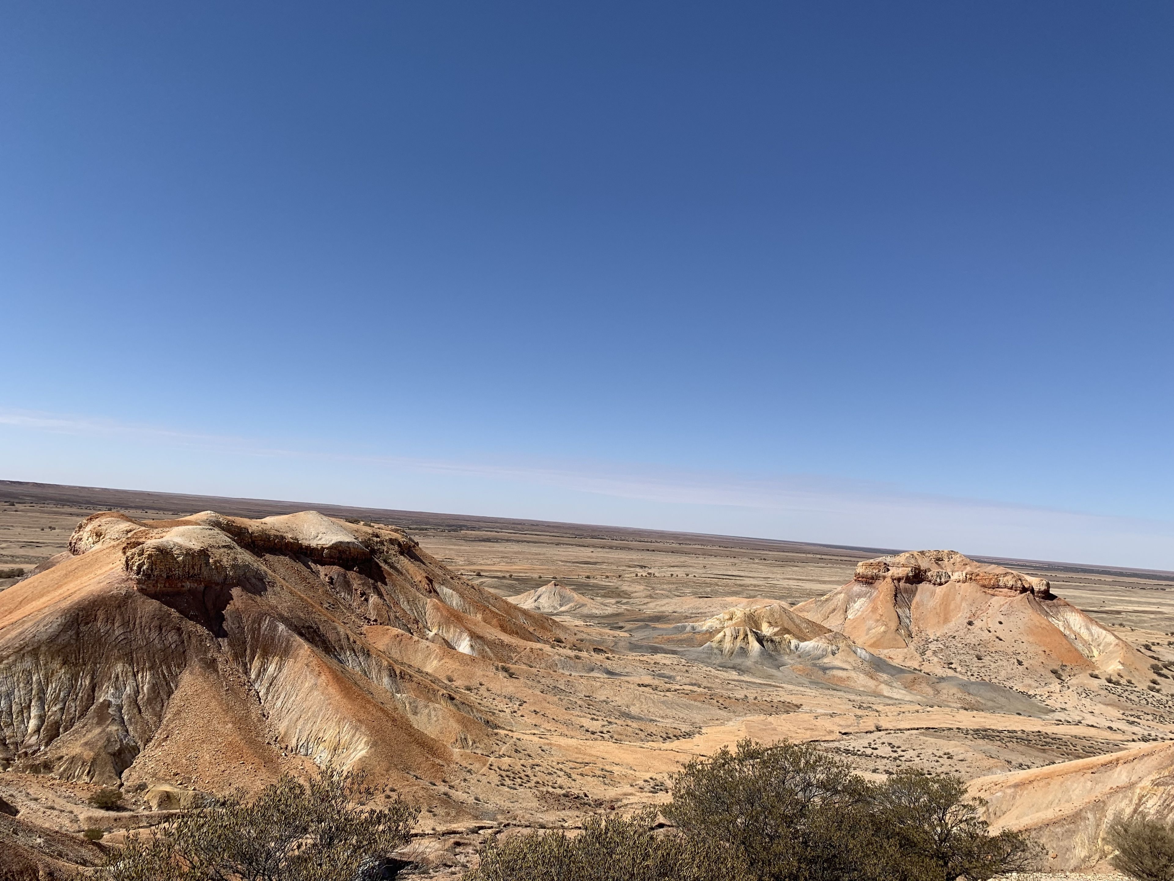 A vast, arid landscape with prominent rock formations and sparse vegetation.