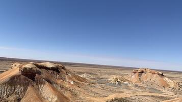 A vast, arid landscape with prominent rock formations and sparse vegetation.