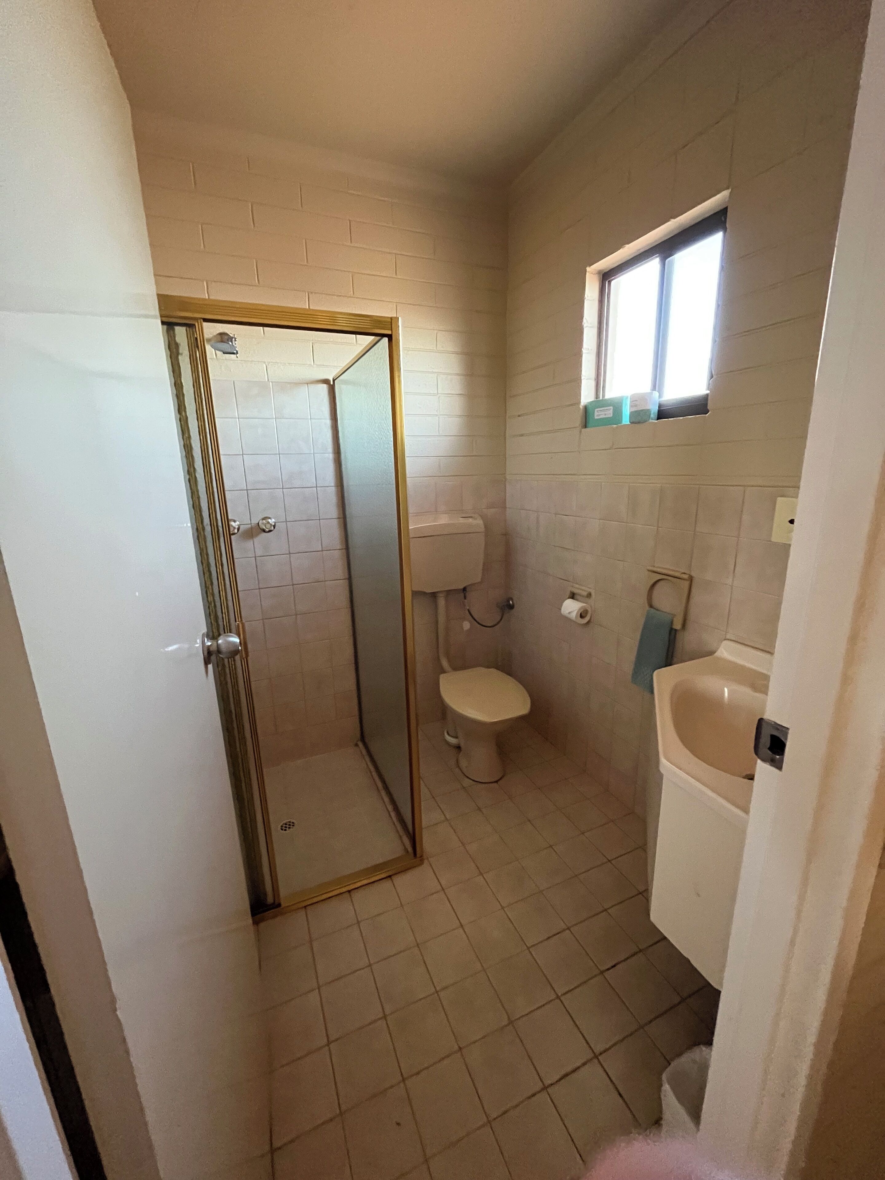 Un baño pequeño con inodoro, lavamanos y ducha.