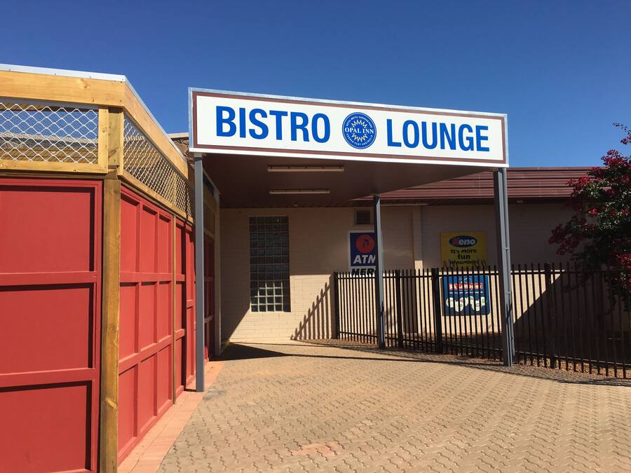 A sign for a Bistro Lounge with an ATM and a Kenzo advertisement.