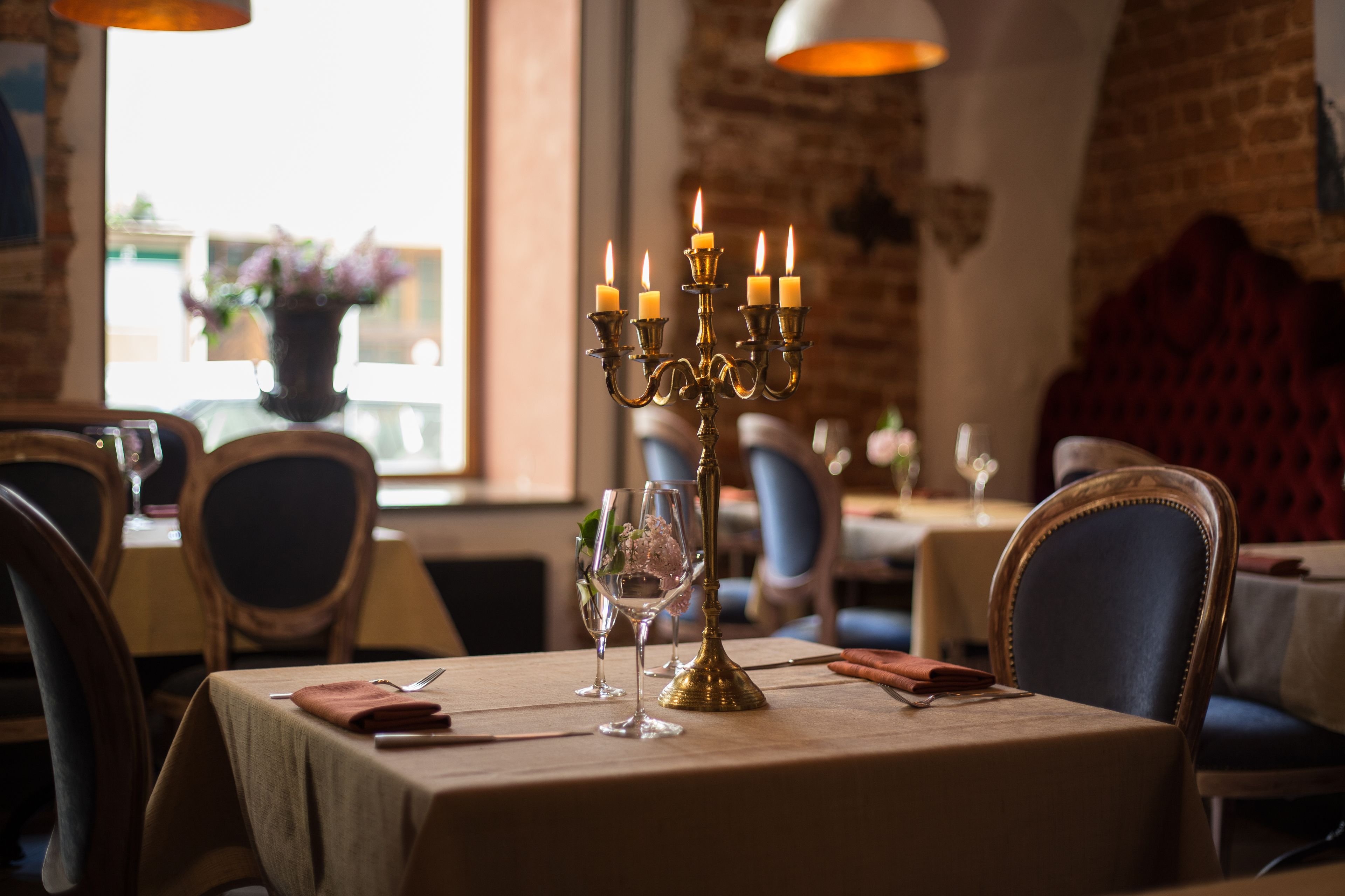 A dining table with a candelabra, wine glasses, and a vase of flowers.