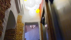 A corridor with a stone wall, a staircase, and a modern elevator.