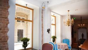 A dining area with a brick wall, large windows, and a chandelier.
