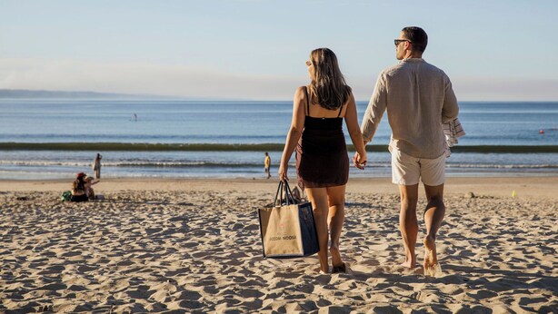 A couple walking on a sandy beach with the ocean in the background. - The Hastings Beach Houses (Noosa Heads)