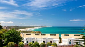 Ein Küstenhotel mit weißen Gebäuden, Blick auf den Strand und einem klaren Himmel.