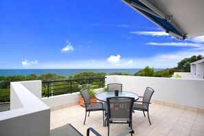 Enjoy ocean views from this terrace with a round table and four chairs.