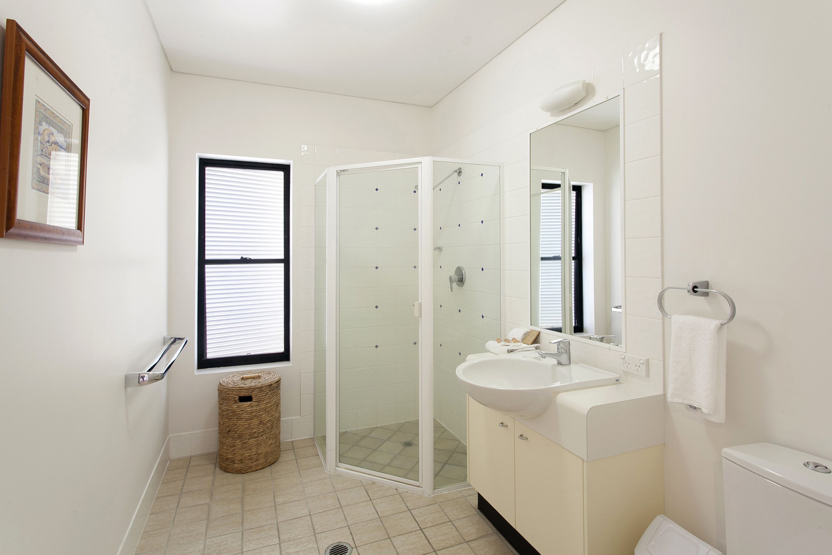 A modern bathroom with a glass-enclosed shower, a sink, and a toilet.