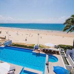 Una piscina al aire libre, sombrillas, sillones reclinables de piscina