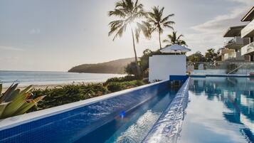 Alberca al aire libre, sombrillas en la alberca y camastros