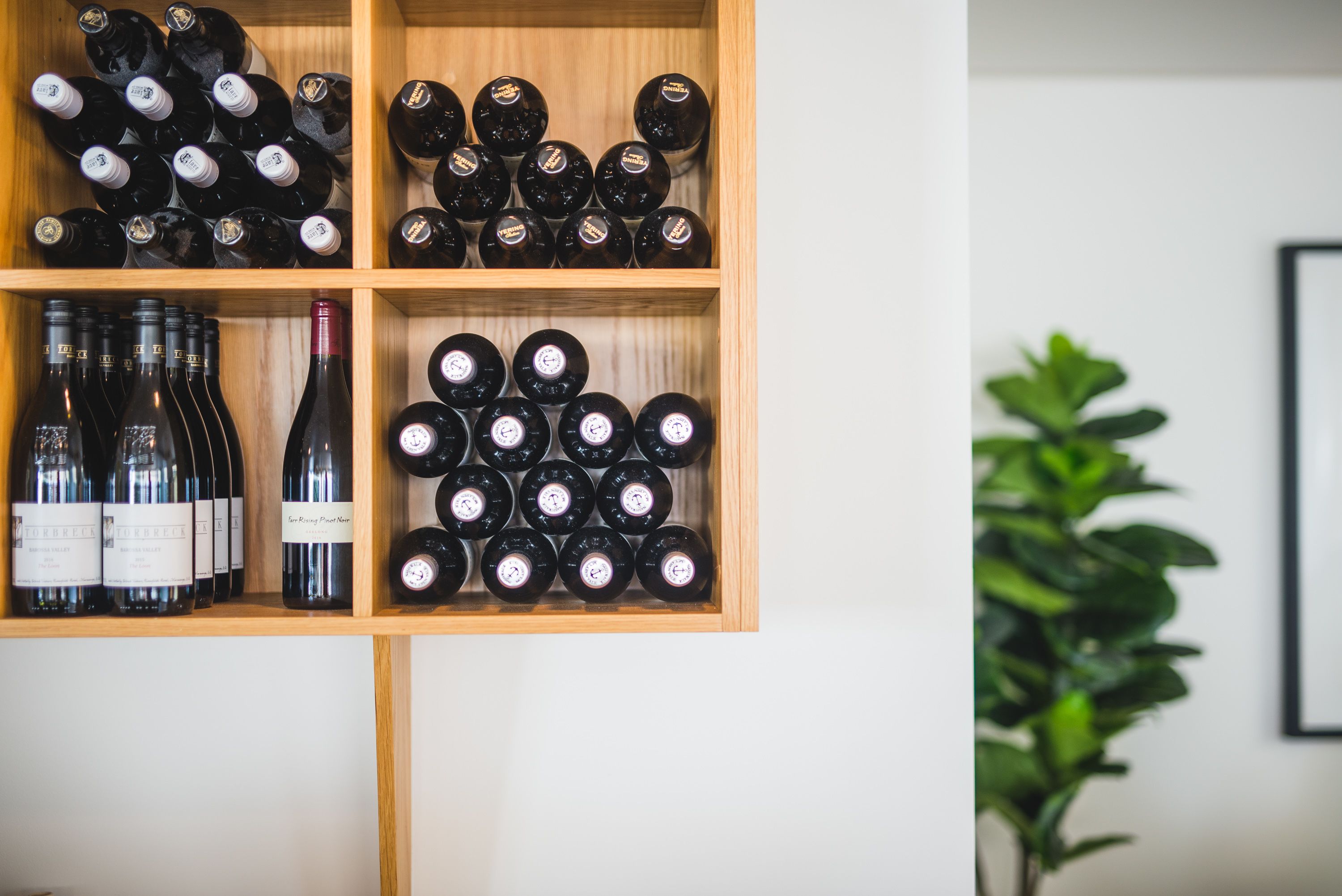 Un meuble à bouteilles contenant plusieurs bouteilles de vin.