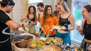 Un grupo de personas en un bufé con diversos platos y cubiertos.