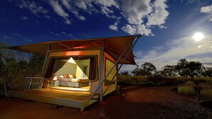 A tent with a bed and seating area, surrounded by natural landscape and a clear night sky. - Karijini Eco Retreat (Karijini)