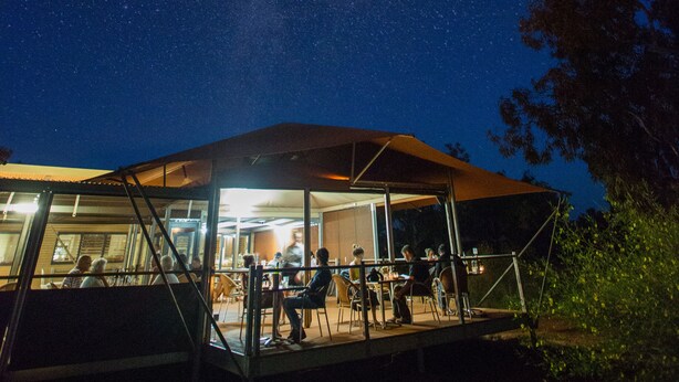 A covered outdoor area with tables and chairs, under a starry night sky. - Karijini Eco Retreat (Karijini)