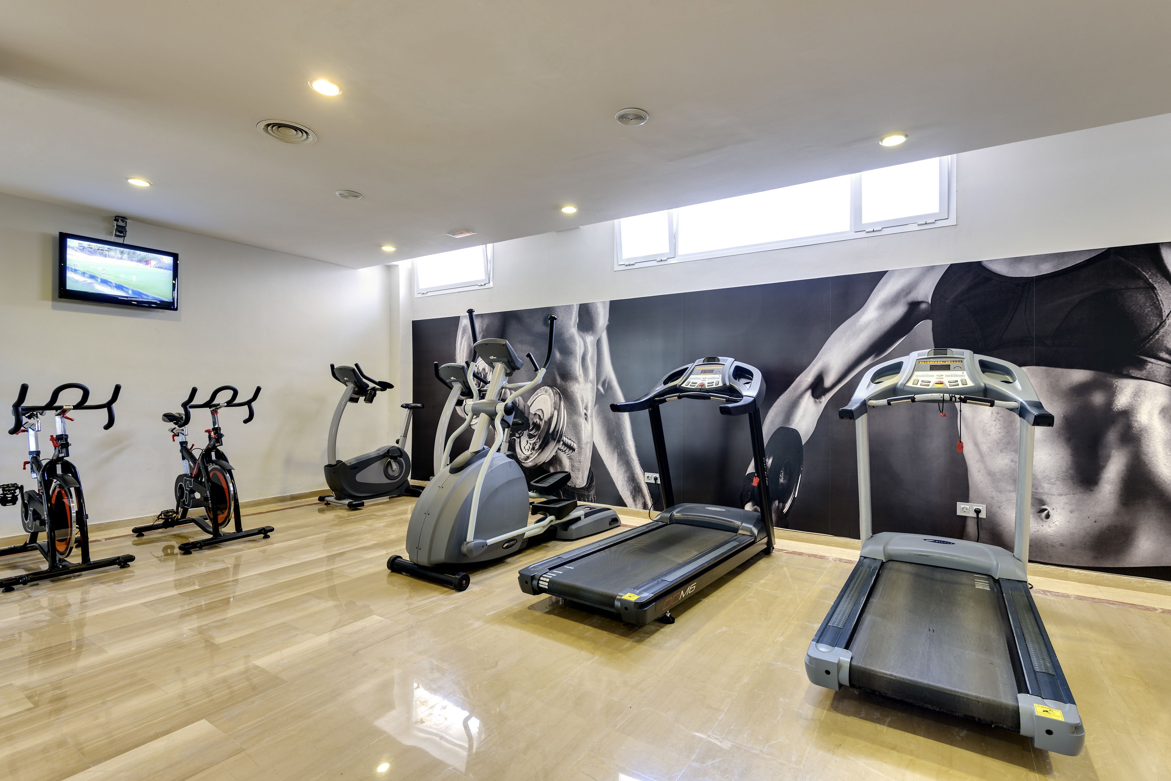 A gym with treadmills, elliptical machines, and stationary bikes.