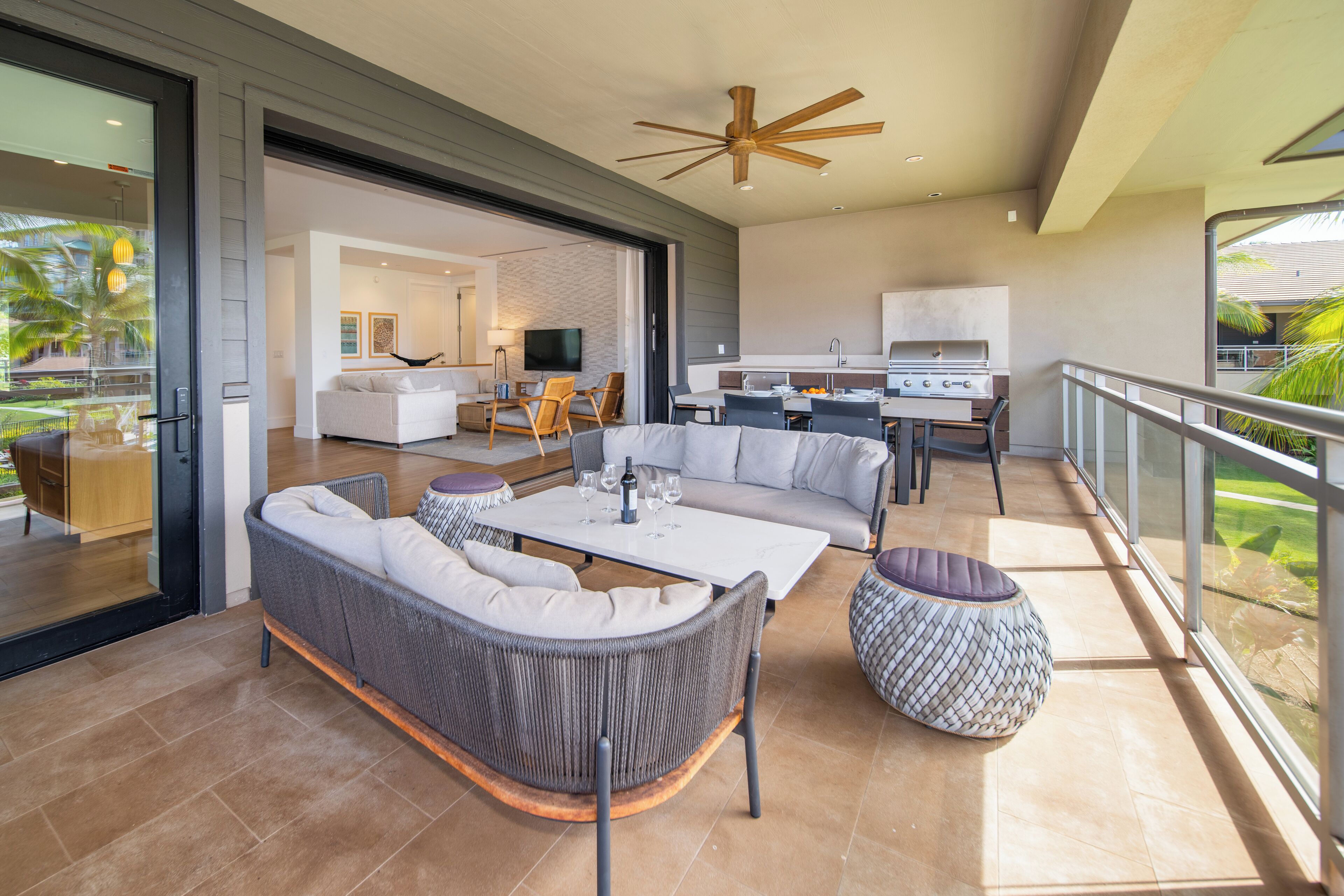 A modern outdoor living area with a sofa, coffee table, and patterned ottoman.