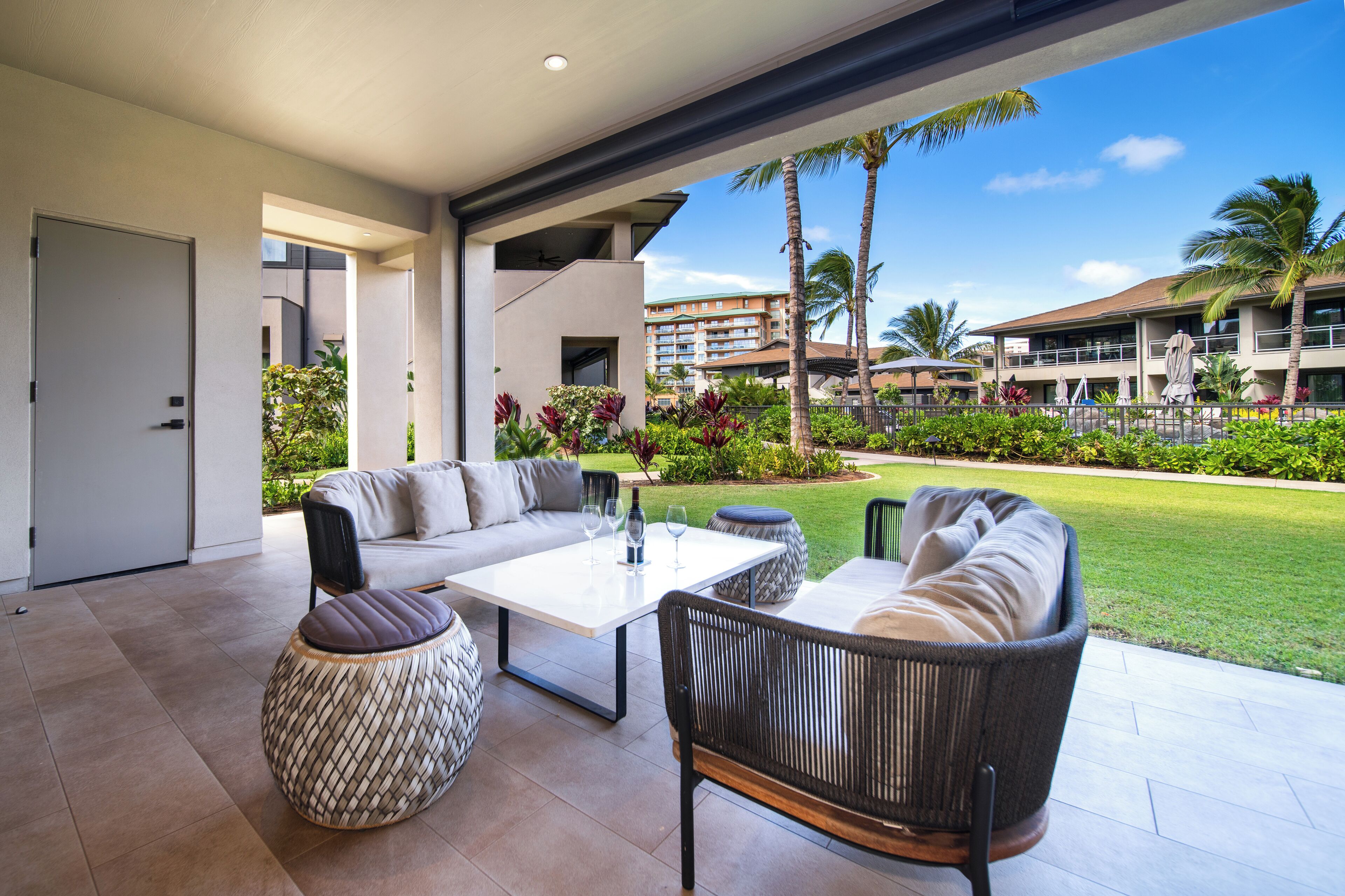 A modern outdoor living area with a sofa, round ottoman, and a coffee table.