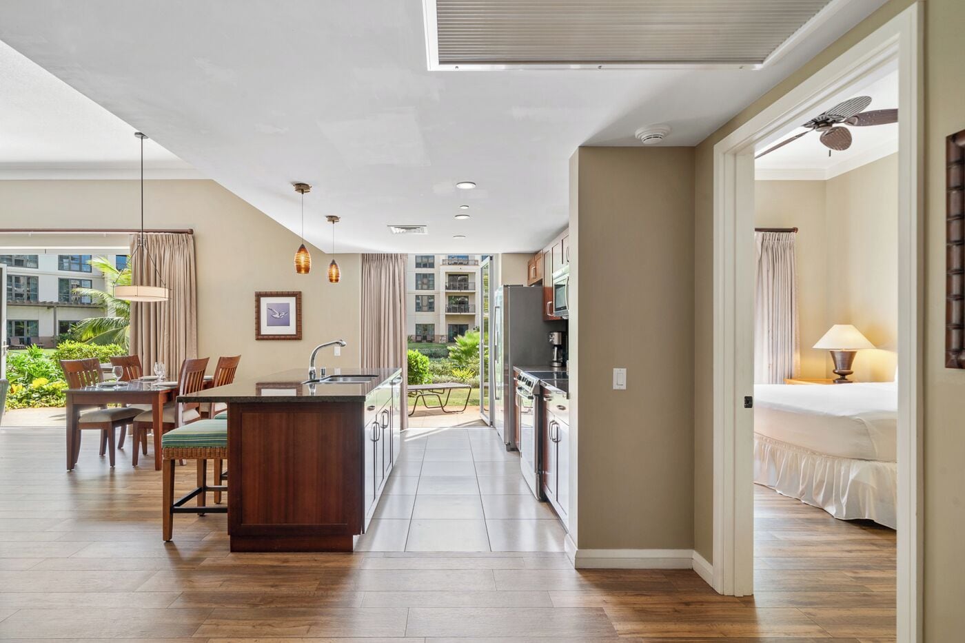 A modern hotel room with a kitchen, dining area, and balcony.