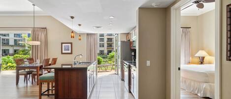 A modern hotel room with a kitchen, dining area, and balcony.
