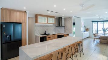 A modern kitchen with a central island, built-in appliances, and a large window providing natural light.