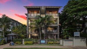Un hôtel à plusieurs étages, doté d’un design moderne, de balcons et d’une façade en pierre.