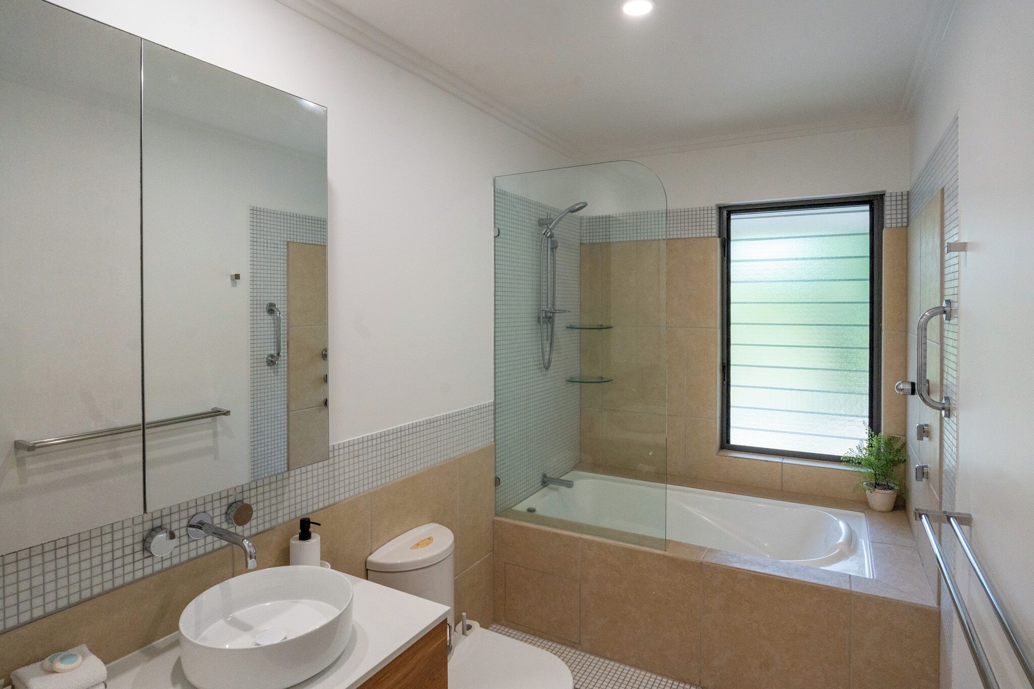 Ein modernes Badezimmer mit einer gläsernen Duschkabine, einer großzügigen Badewanne und einem weißen Waschbecken.