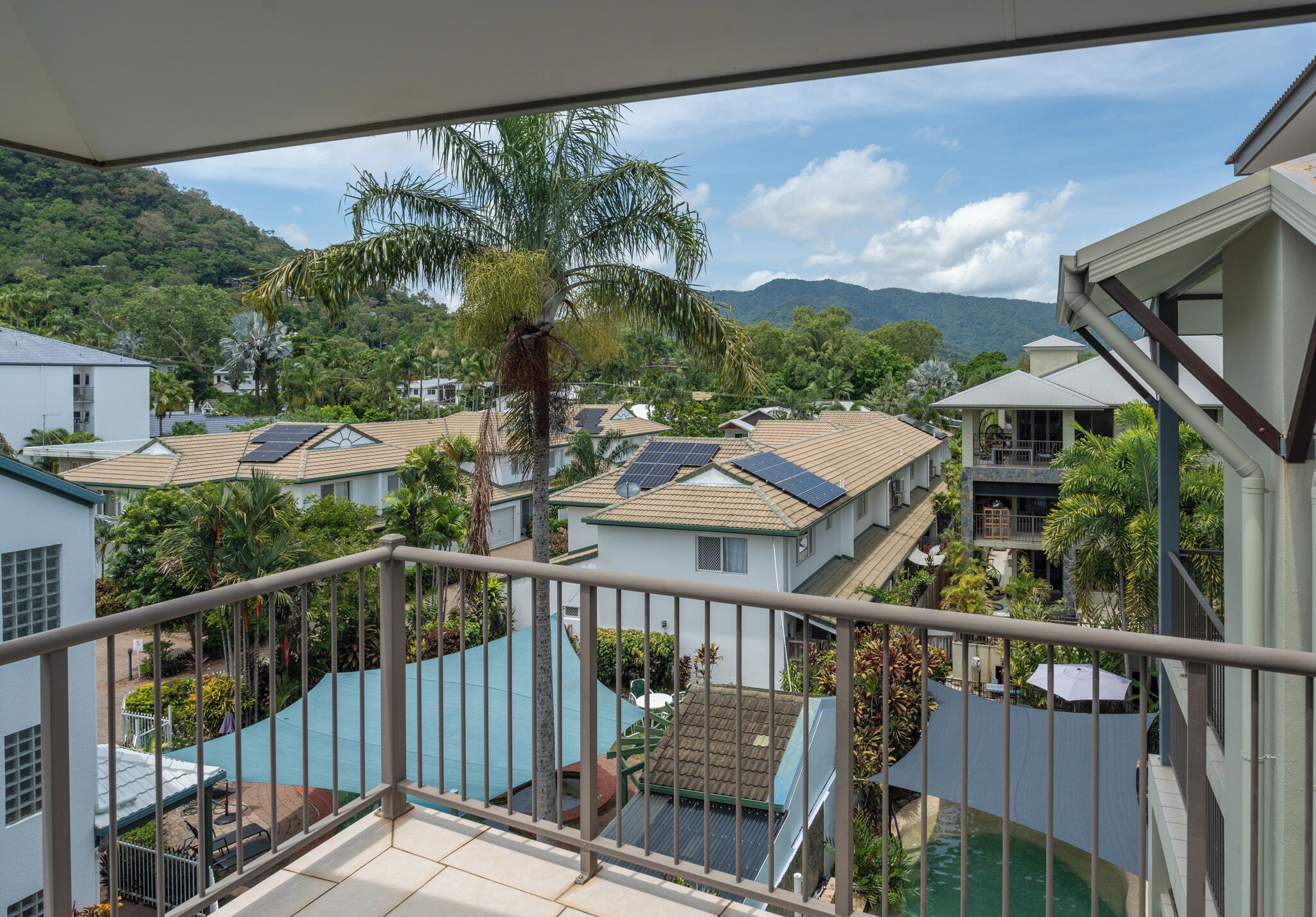 Un área residencial con casas, una piscina y paneles solares en los tejados.
