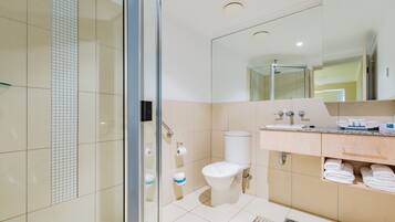 Ein modernes Badezimmer mit Duschkabine aus Glas, Toilette und Waschtisch mit Spiegel.