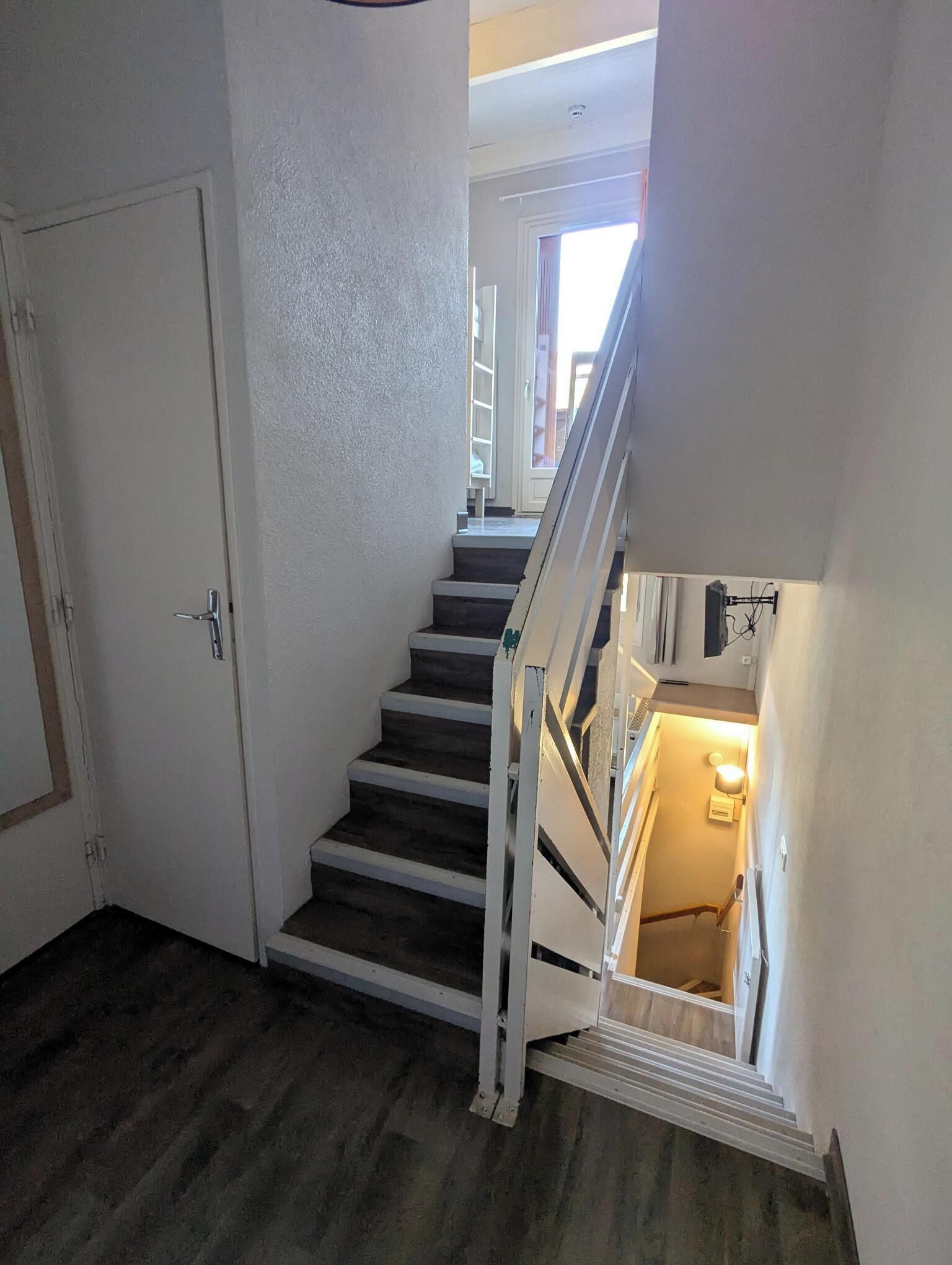 Un escalier avec une rampe menant à un palier.