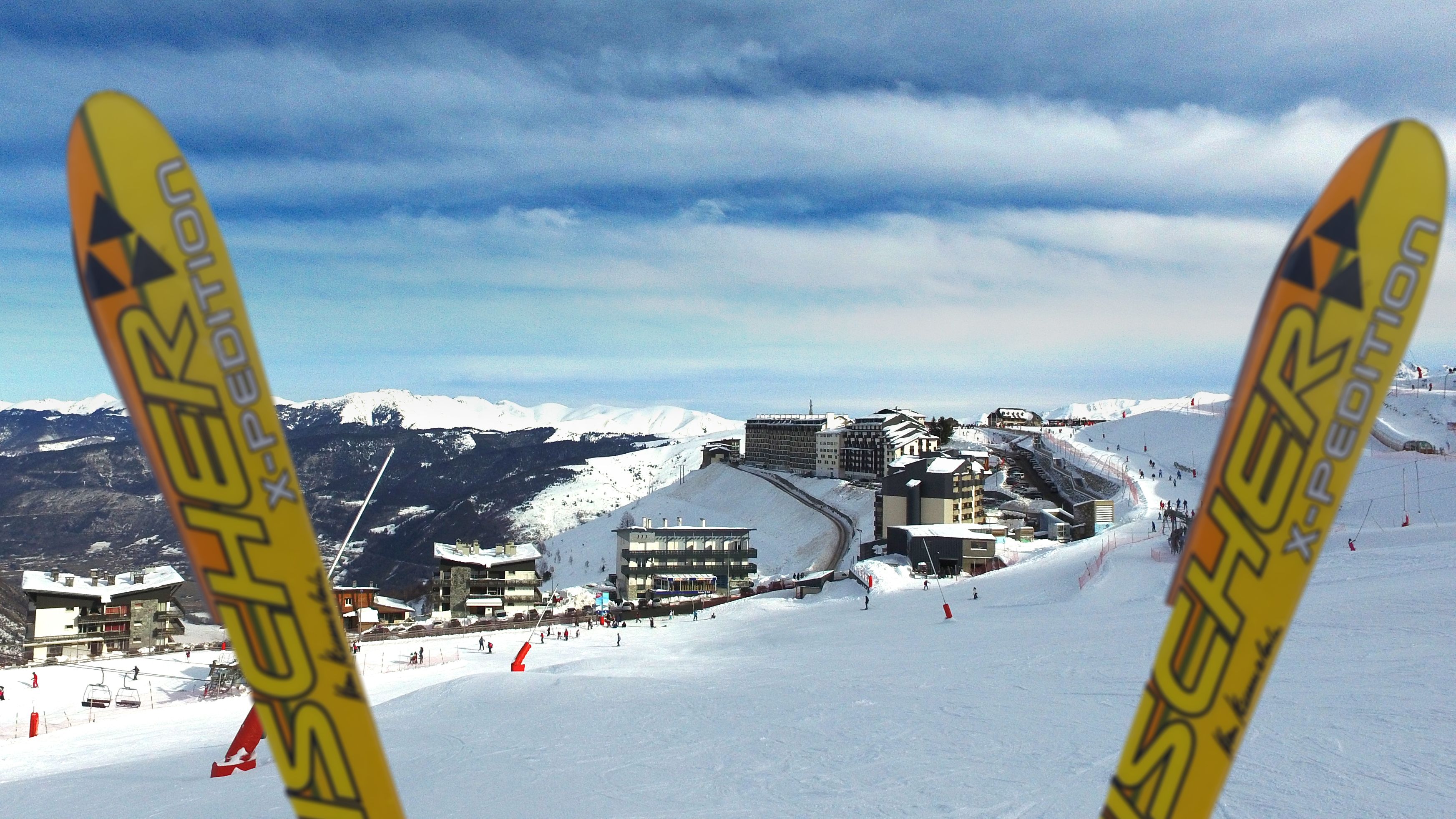 Une station de ski dotée d'un télésiège, de bâtiments et offrant une vue sur une montagne enneigée.