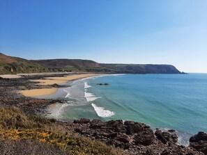 Un paisaje costero con playa, costa rocosa y acantilados.