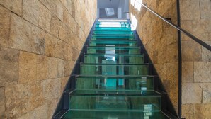 Una escalera con escalones de vidrio y paredes de piedra.