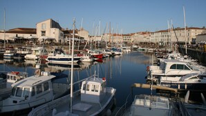 A marina with various boats docked, surrounded by buildings. - VVF Île de Ré Sainte-Marie-de-Ré (Sainte-Marie-de-Re)