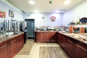 Una cocina moderna con electrodomésticos de acero inoxidable, armarios de madera y una amplia gama de utensilios de cocina.