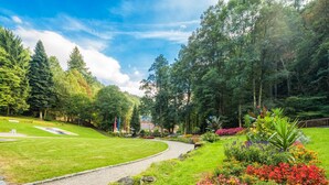 Ein angelegter Garten mit Kiesweg, verschiedenen Pflanzen und Bäumen.