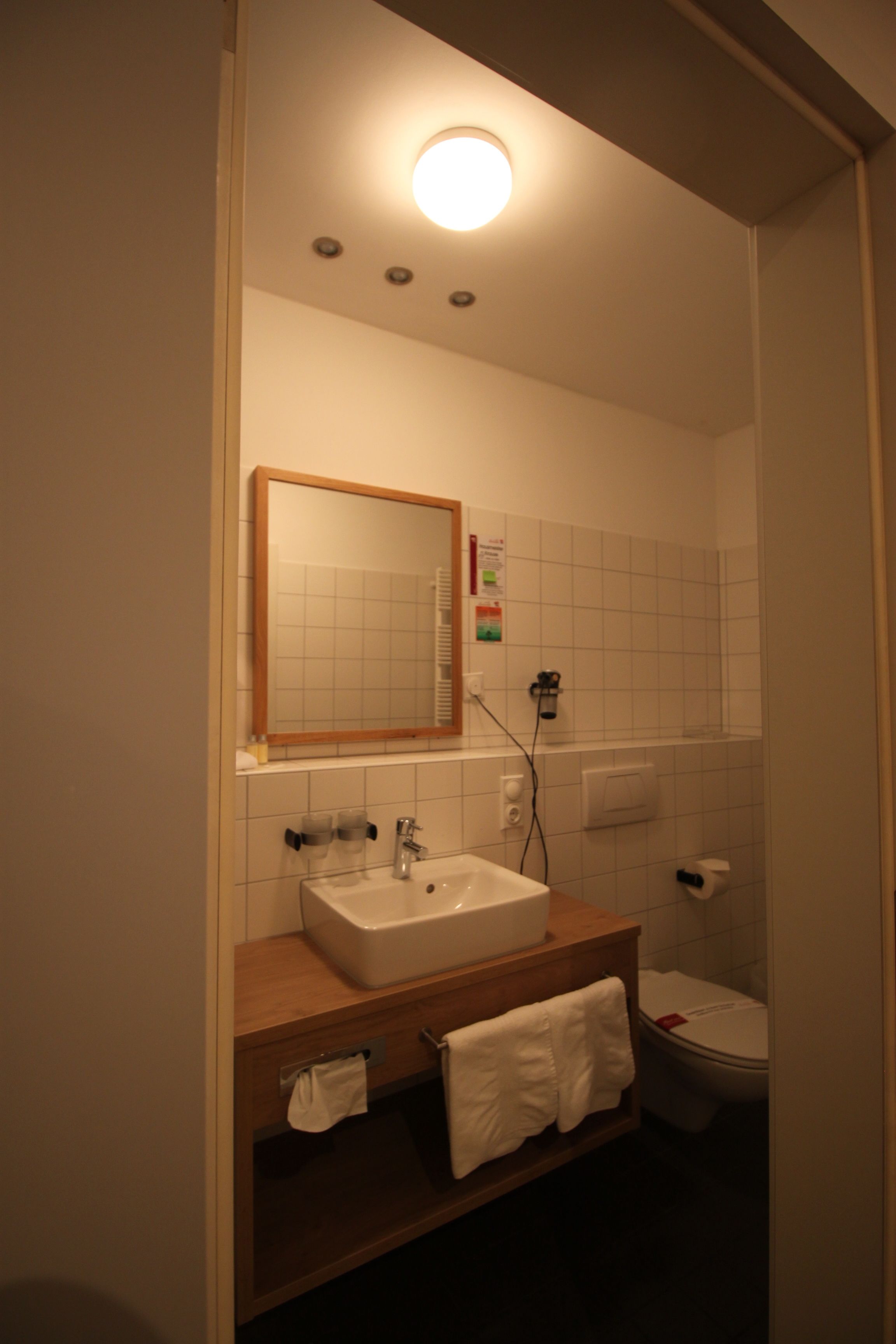 A bathroom with a sink, mirror, and toilet.