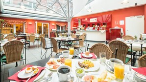 Ein Frühstücksbuffet mit Tischen, Stühlen und verschiedenen Speisen und Getränken, darunter Eier, Toast und Aufguss.