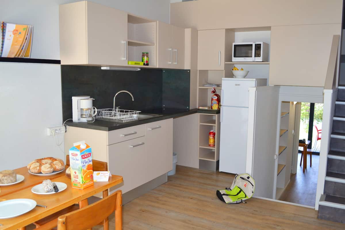 A modern kitchen with a dining area, a microwave, and a refrigerator.