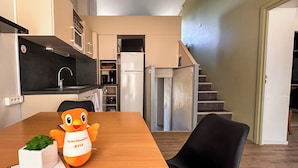 A modern kitchen with a dining table, a plush toy, and a small plant. - VVF Haute Loire Saint-Julien-Chapteuil (Saint-Julien-Chapteuil)