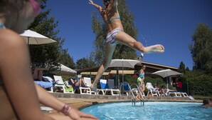Un área de piscina con sillas de descanso y sombrillas.