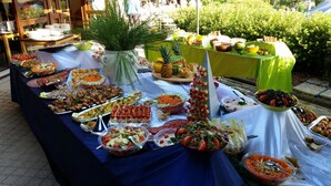 Una mesa de buffet con diferentes alimentos y una planta en maceta.