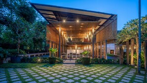 A modern building with a covered outdoor area, a dining space, and a garden with a patterned walkway. - Kayumanis Nusa Dua Private Villa & Spa (Nusa Dua)