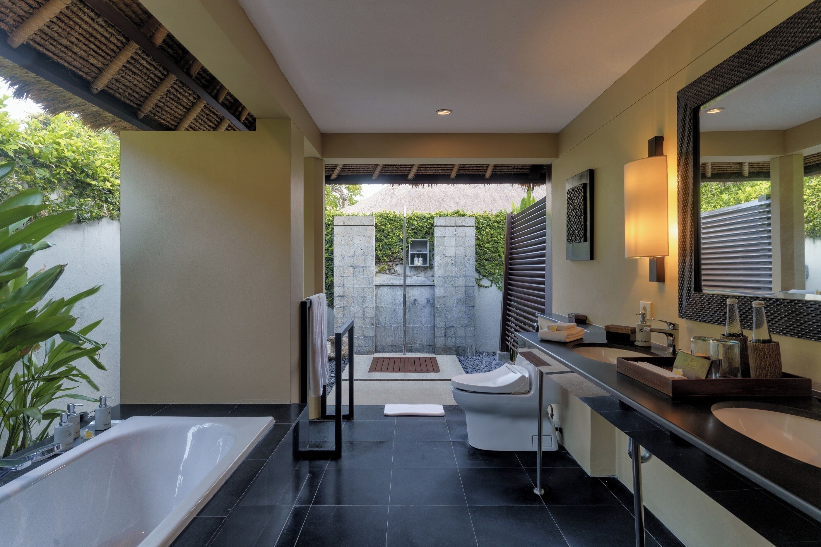 Un baño moderno con bañera, dos lavamanos, un espejo grande y zona de ducha.