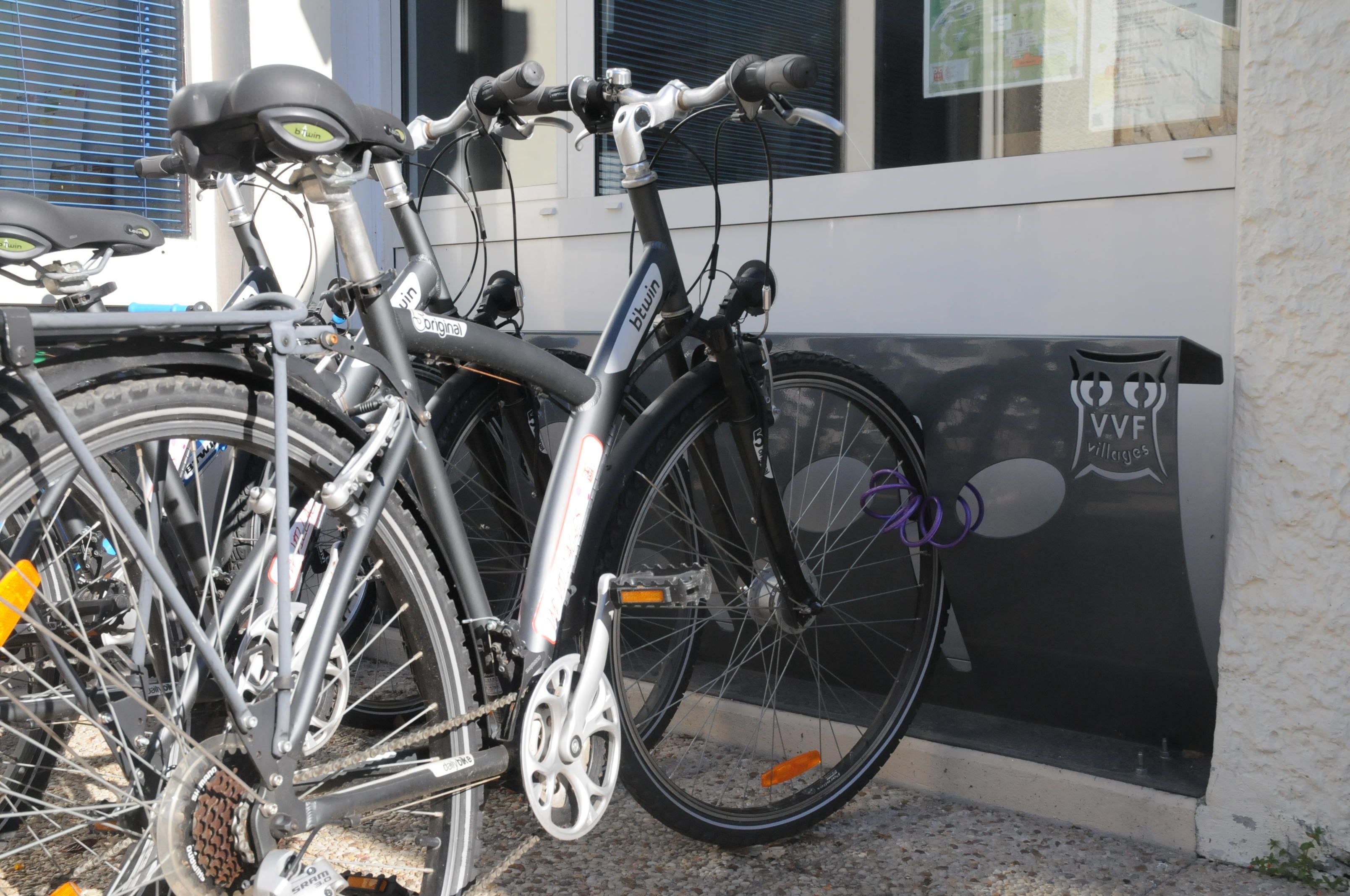 A bicycle parked next to a building with a window and a door.