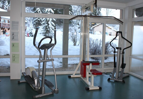 A gym with exercise equipment and large windows.