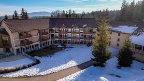A multi-story building with balconies, a courtyard, and a snowy landscape. - VVF Jura Les Rousses, Prémanon (Premanon)