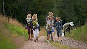 Een groep mensen loopt over een onverhard pad, omringd door begroeiing.