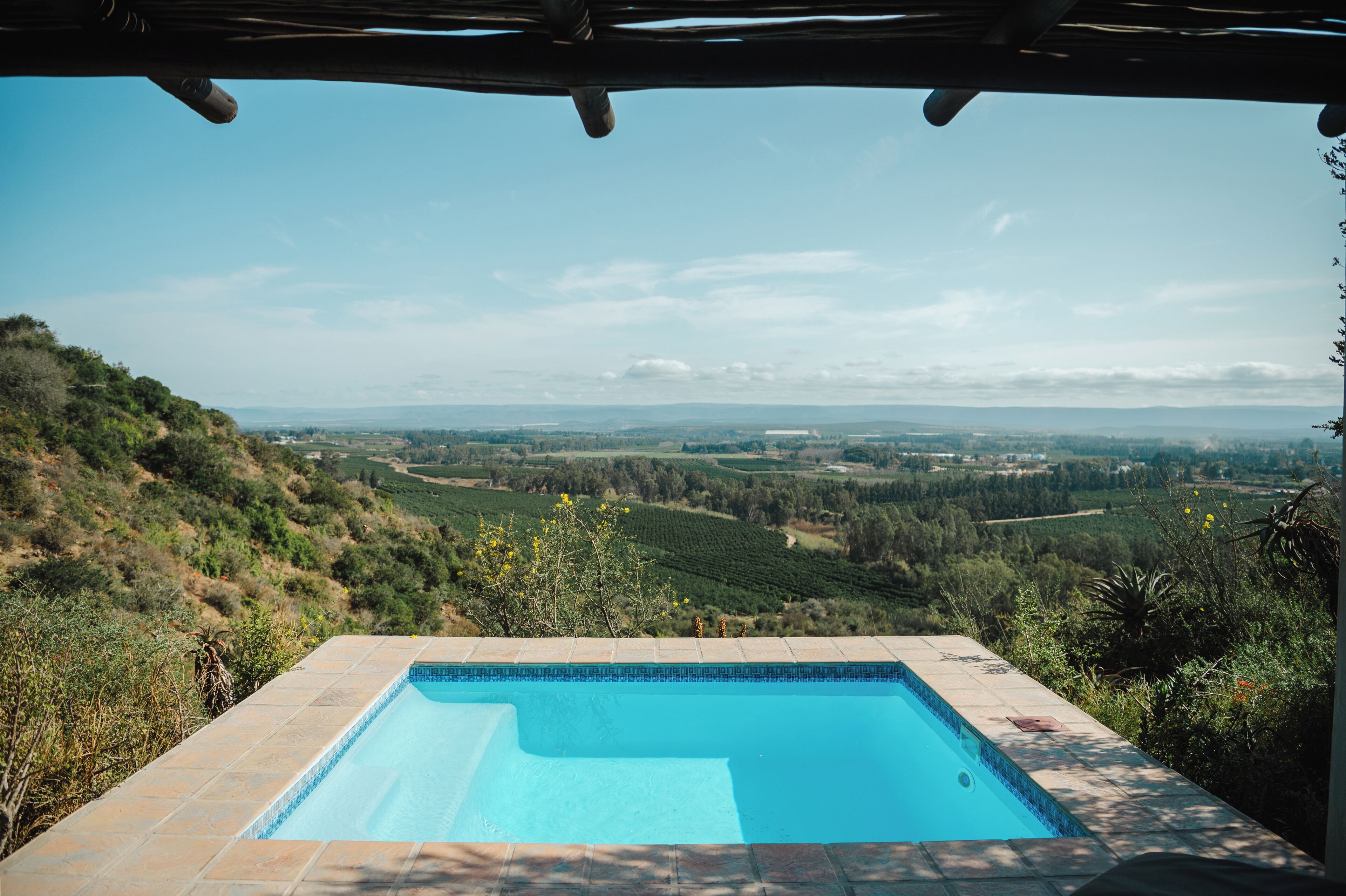 A swimming pool with a view of a hilly landscape.